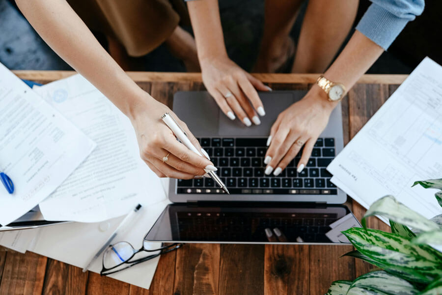 Vue d'en haut de personnes travaillant au-dessus d'un laptop